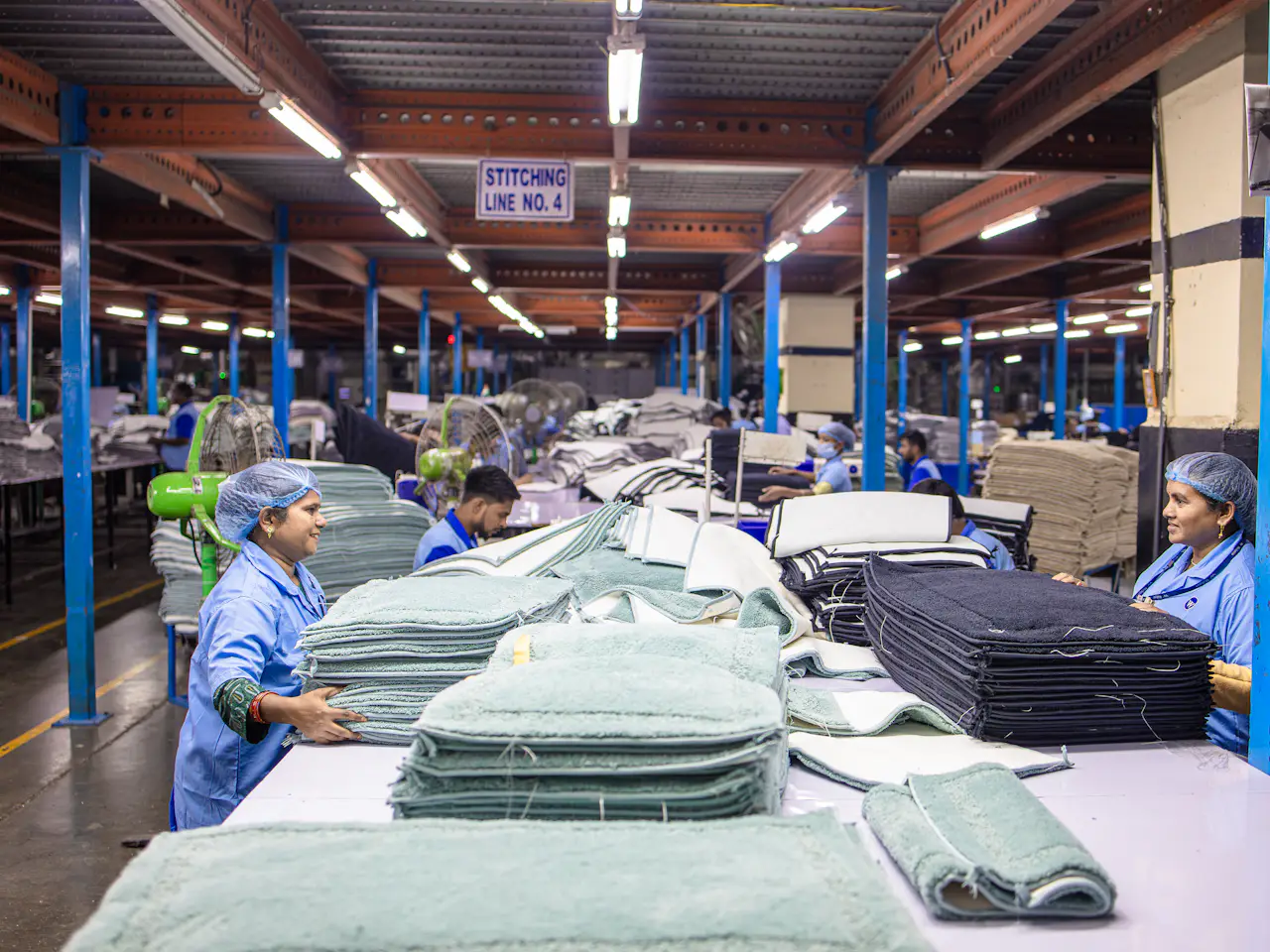 Fabrika zemininde biten kumaşı ayıran tekstil işçileri
